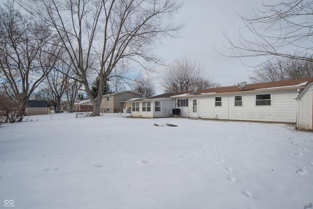 snow covered back of property with central AC unit