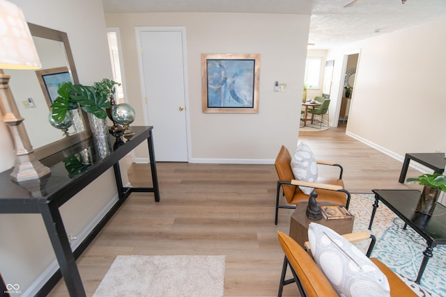 corridor with light hardwood / wood-style floors and a textured ceiling