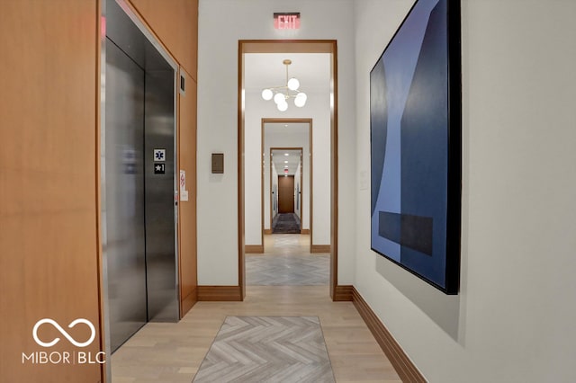 hallway with elevator and light parquet flooring