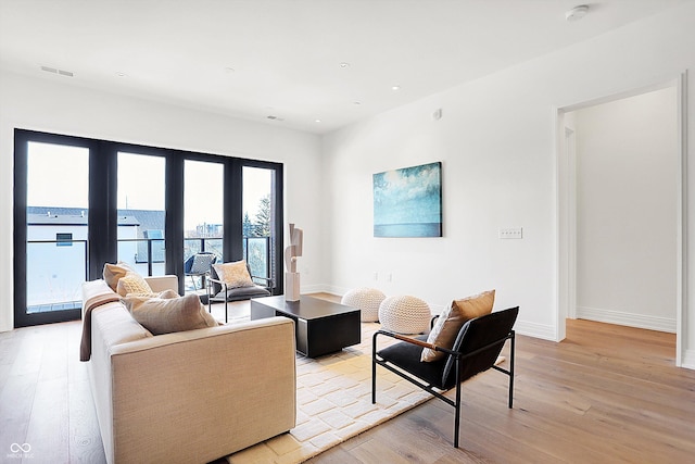 living room with a water view and light wood-type flooring