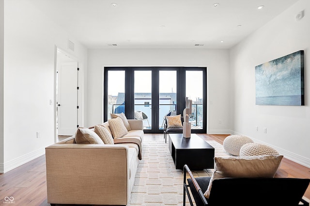 living room with light wood-type flooring and french doors