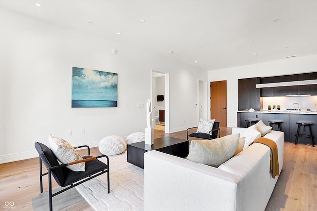 living room featuring sink and light hardwood / wood-style floors