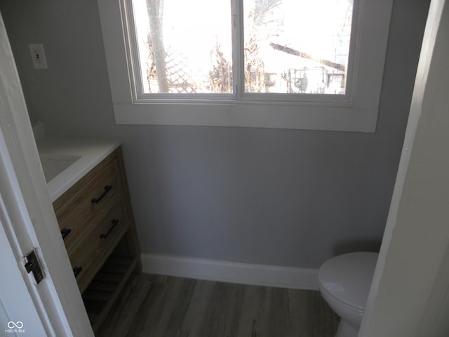 bathroom featuring vanity, toilet, wood-type flooring, and plenty of natural light