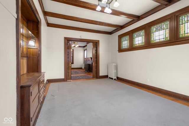 1023 Franklin St, Columbus, IN 47201 - spare room featuring radiator heating unit and beamed ceiling