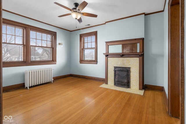1023 Franklin St, Columbus, IN 47201 - unfurnished living room with ceiling fan, radiator, ornamental molding, and light hardwood / wood-style flooring