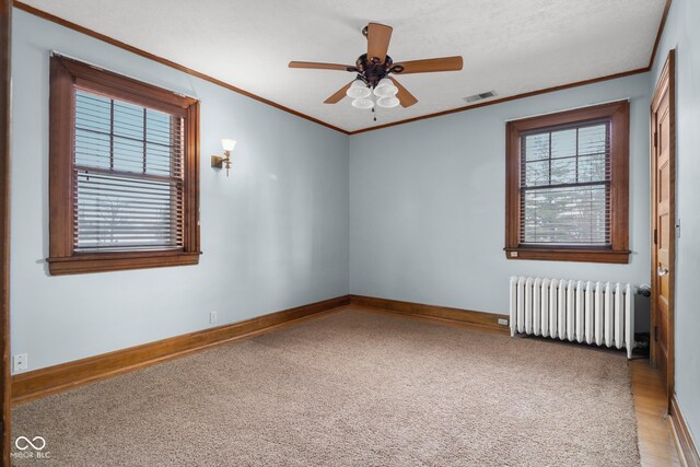1023 Franklin St, Columbus, IN 47201 - spare room with ceiling fan, radiator heating unit, ornamental molding, and carpet floors