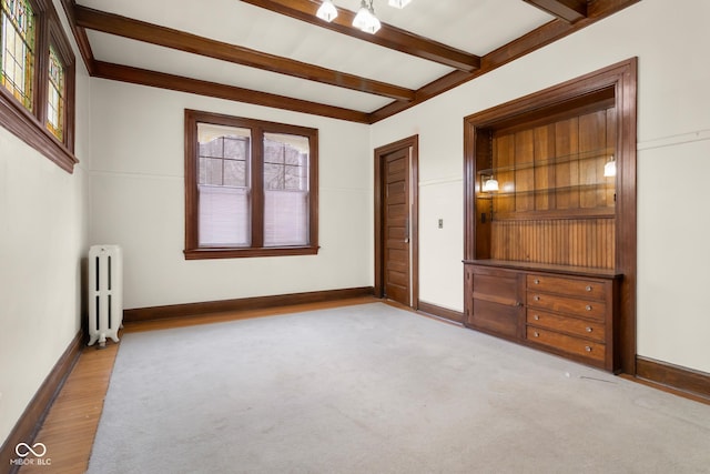 1023 Franklin St, Columbus, IN 47201 - empty room with radiator heating unit, beamed ceiling, and a healthy amount of sunlight