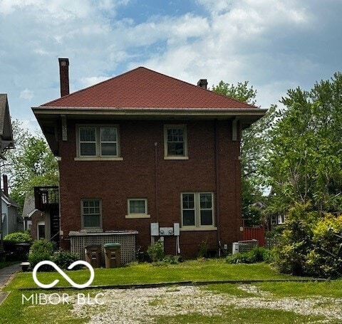 1023 Franklin St, Columbus, IN 47201 - rear view of house featuring a chimney and a lawn