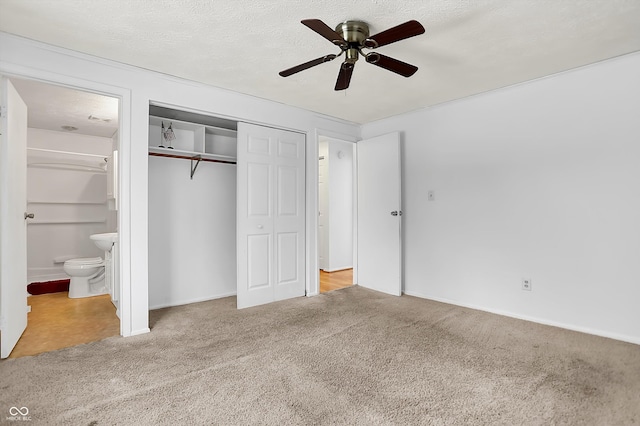 unfurnished bedroom with connected bathroom, a closet, ceiling fan, and carpet