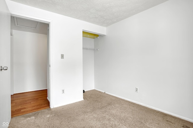 unfurnished bedroom with carpet, a textured ceiling, and a closet