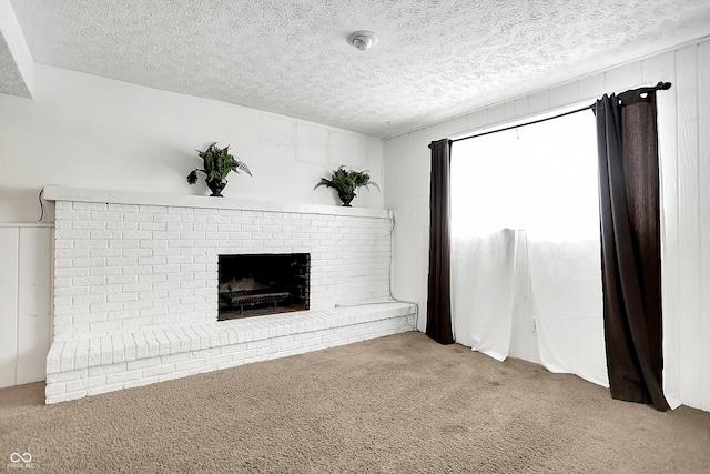 unfurnished living room with a fireplace, a textured ceiling, and carpet