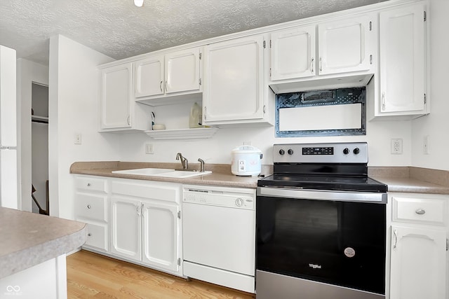 kitchen with stainless steel electric range oven, sink, white cabinets, white dishwasher, and light hardwood / wood-style floors