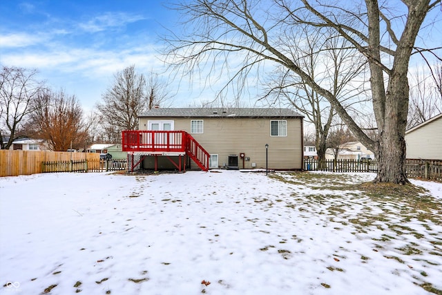 snow covered house with a wooden deck