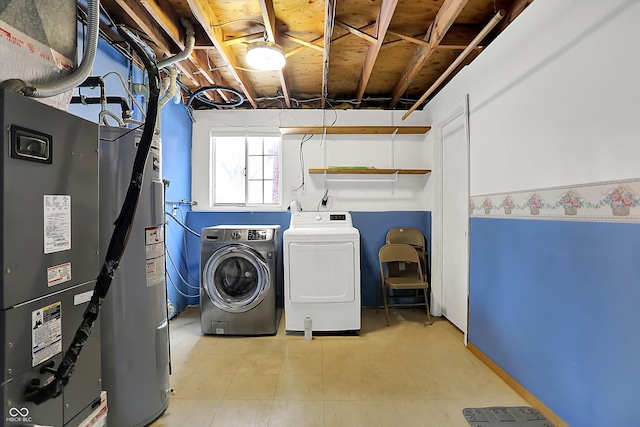 clothes washing area featuring separate washer and dryer and electric water heater