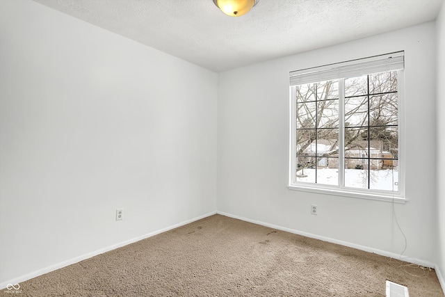 carpeted empty room with a textured ceiling