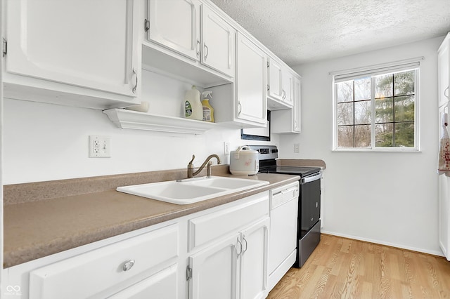 kitchen with sink, white cabinets, and a textured ceiling