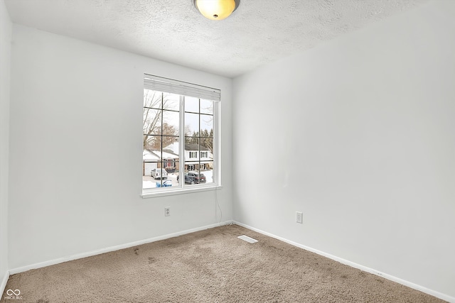 spare room with a textured ceiling and carpet flooring