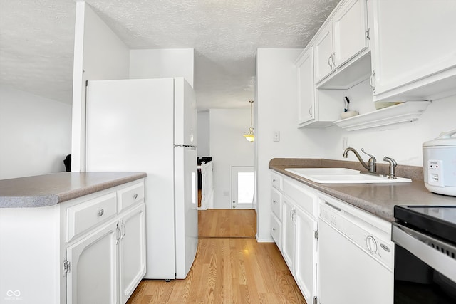 kitchen with sink, white cabinetry, light hardwood / wood-style flooring, pendant lighting, and white appliances