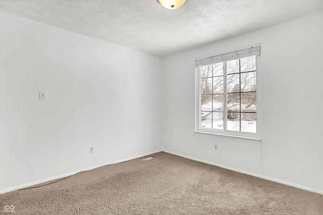 carpeted spare room with a textured ceiling