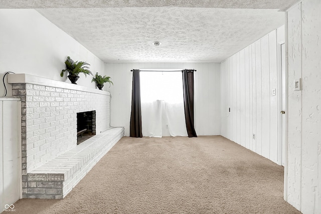 unfurnished living room with a brick fireplace, light carpet, and a textured ceiling