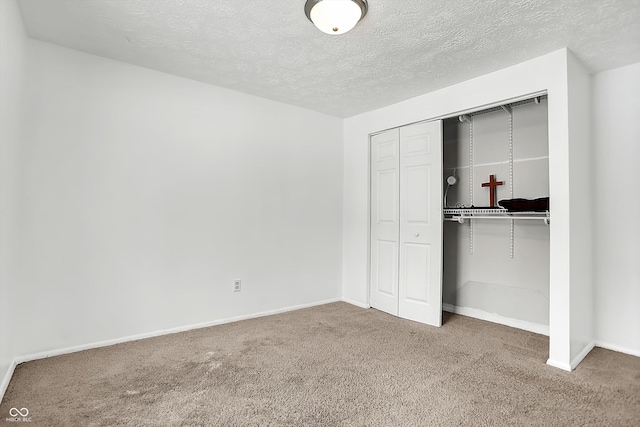 unfurnished bedroom with a closet, a textured ceiling, and carpet flooring