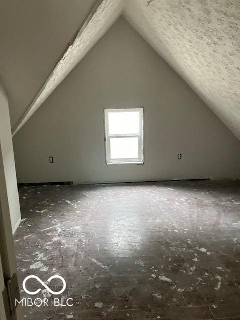 bonus room with vaulted ceiling and a textured ceiling