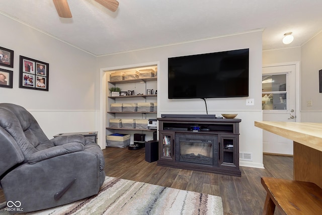 living room with crown molding, dark hardwood / wood-style floors, and ceiling fan