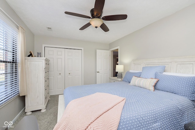 carpeted bedroom featuring ceiling fan and a closet