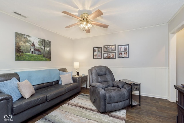 living room with dark wood-type flooring, ceiling fan, and ornamental molding