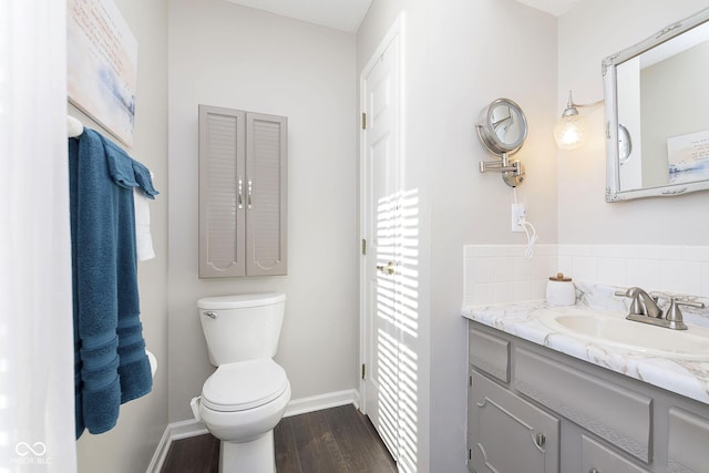 bathroom featuring hardwood / wood-style flooring, vanity, toilet, and backsplash