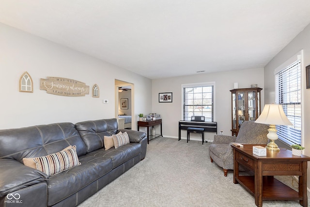 carpeted living room with ceiling fan