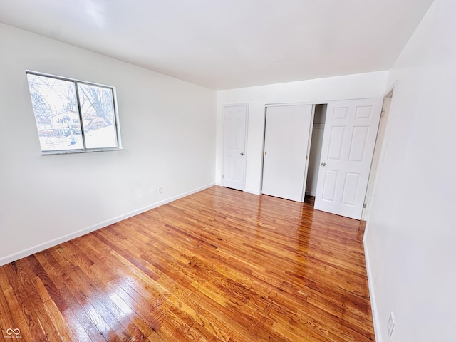 unfurnished bedroom with a closet and hardwood / wood-style flooring