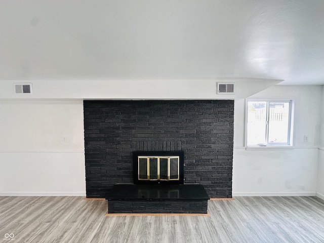 interior details with wood-type flooring and a fireplace