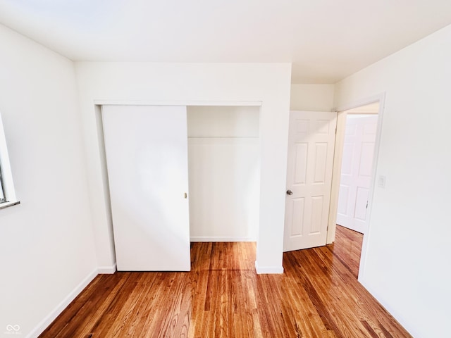 unfurnished bedroom with a closet and hardwood / wood-style flooring