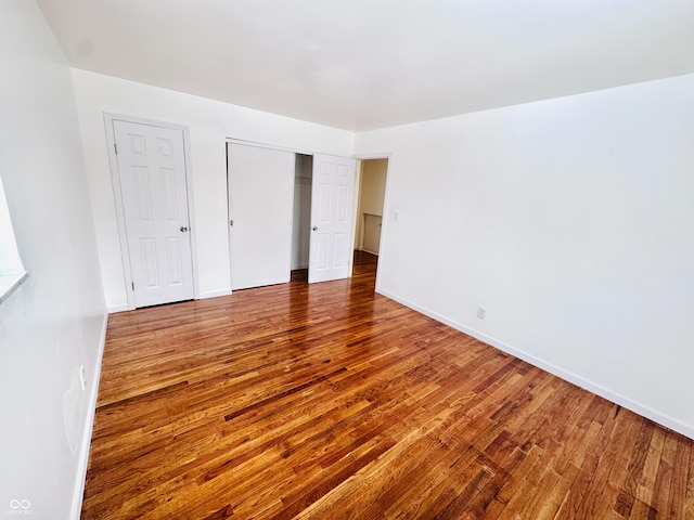 unfurnished bedroom featuring wood-type flooring and a closet