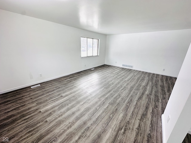 unfurnished room with dark wood-type flooring