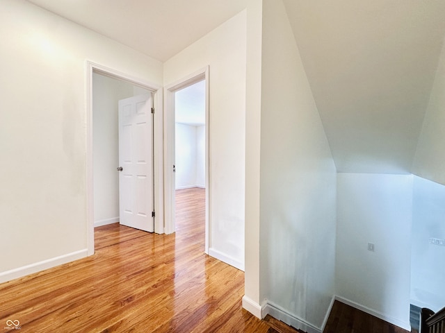 hall featuring lofted ceiling and light wood-type flooring