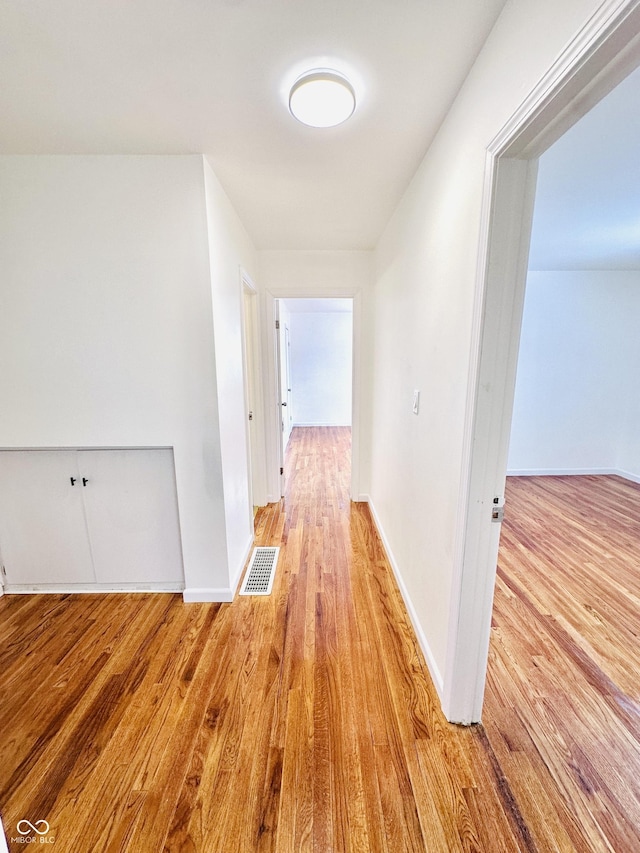 corridor with light hardwood / wood-style floors