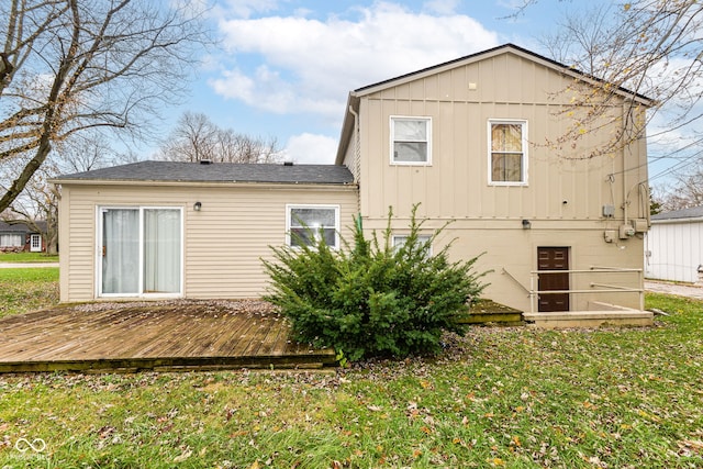 rear view of property with a wooden deck and a yard