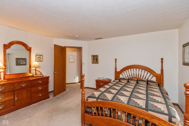 bedroom with light carpet and a textured ceiling