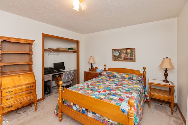 carpeted bedroom with a closet and a textured ceiling