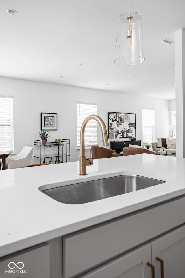 details featuring dishwashing machine, sink, hanging light fixtures, and gray cabinets