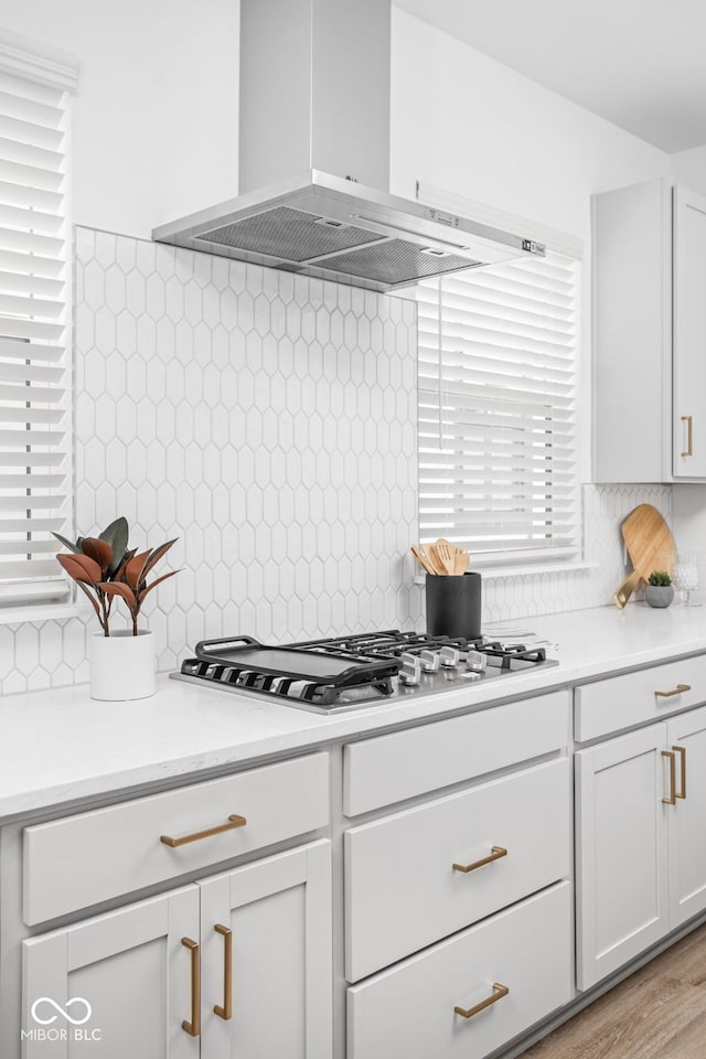 kitchen with white cabinetry, backsplash, and extractor fan