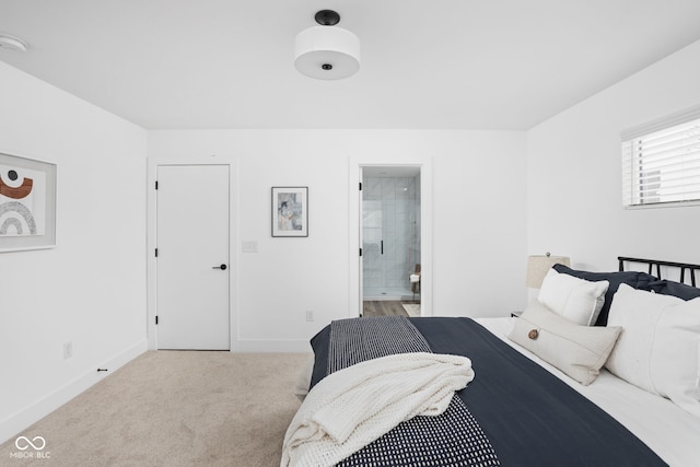 bedroom featuring light carpet and ensuite bathroom