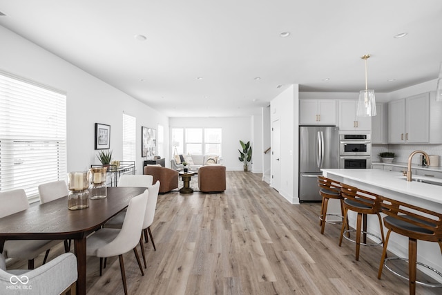 dining space with sink and light hardwood / wood-style floors