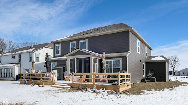 snow covered property with a sunroom and a deck