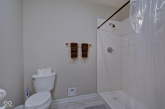 bathroom featuring toilet and curtained shower