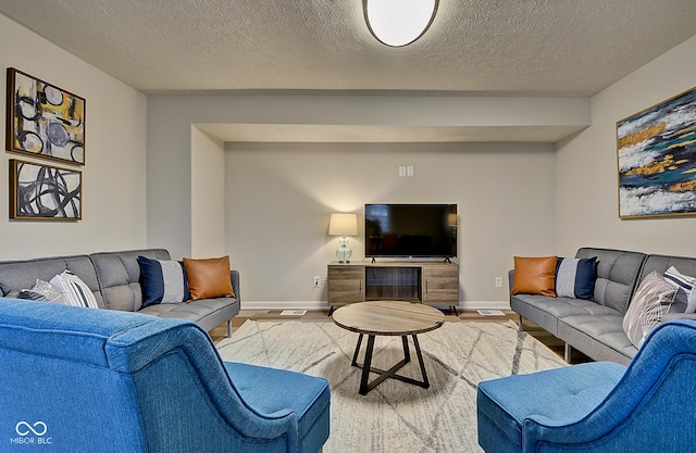 living room with light hardwood / wood-style floors and a textured ceiling