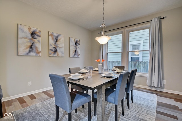 dining area with hardwood / wood-style floors and a textured ceiling