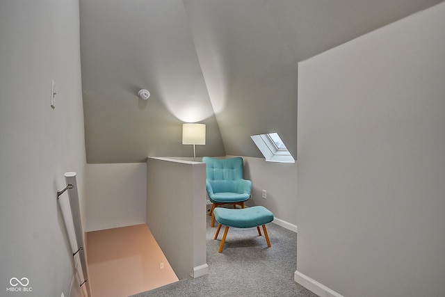 sitting room with carpet flooring and vaulted ceiling with skylight